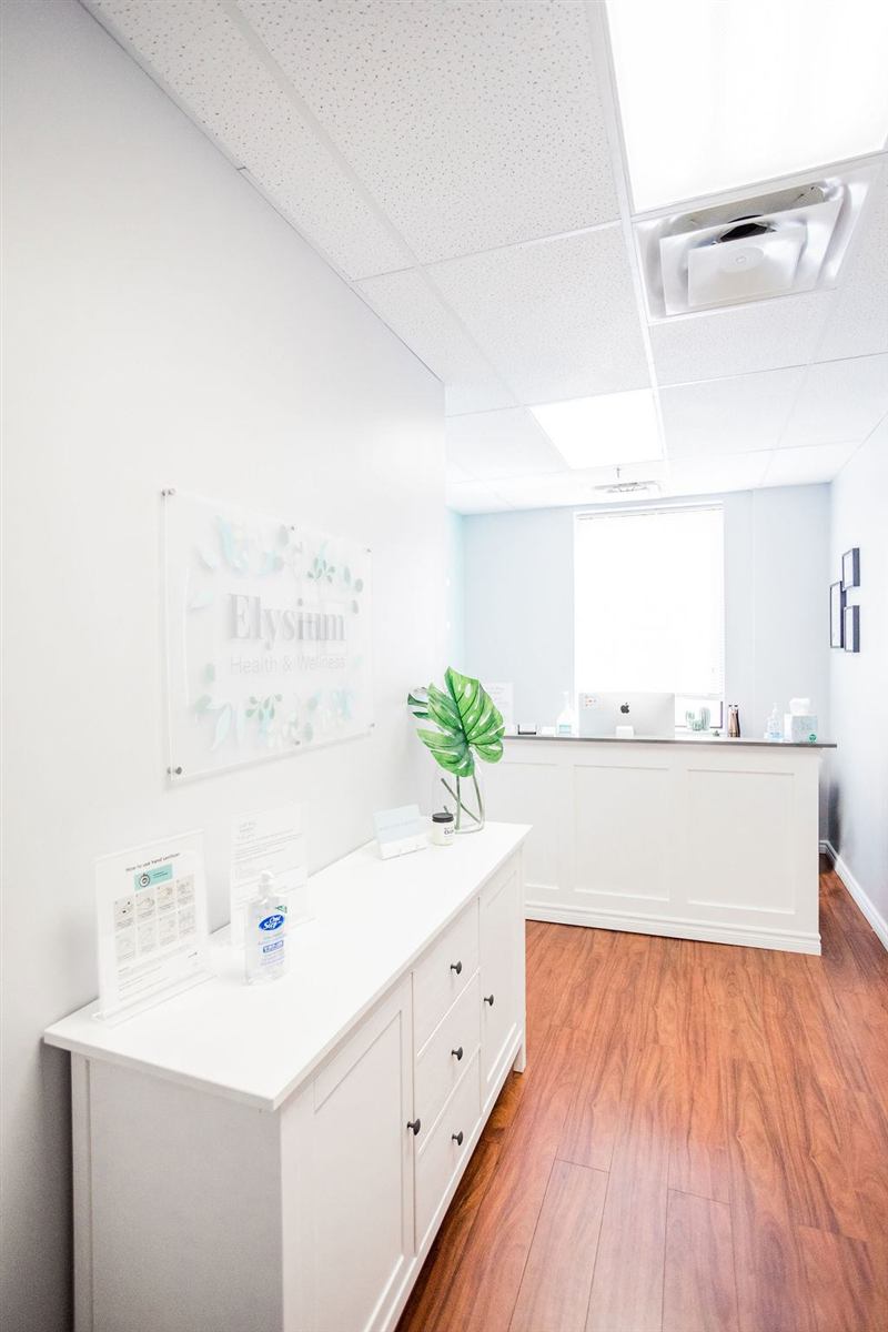 Bright reception area with the Elysium sign, a white cabinet and a front desk